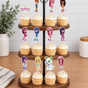 May include: A three-tiered wooden cupcake stand holding twelve cupcakes topped with Strawberry Shortcake character paper toppers. Each cupcake features white frosting with colorful sprinkles and a unique character cutout on a wooden pick.