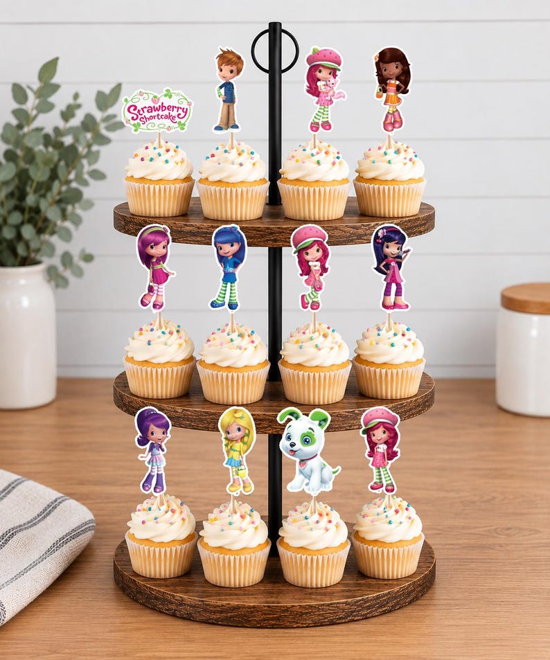 May include: A three-tiered wooden cupcake stand holding twelve cupcakes topped with Strawberry Shortcake character paper toppers. Each cupcake features white frosting with colorful sprinkles and a unique character cutout on a wooden pick.