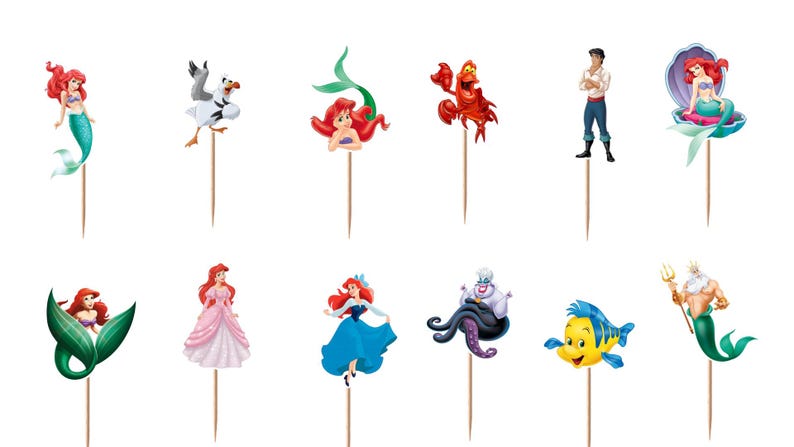 Puede incluir: Un conjunto de doce adornos para cupcakes con varios personajes de La Sirenita, incluyendo a Ariel en diferentes poses, Sebasti&aacute;n, Flounder, el Rey Trit&oacute;n, &Uacute;rsula y el Pr&iacute;ncipe Eric, cada uno unido a un palillo de madera fino.