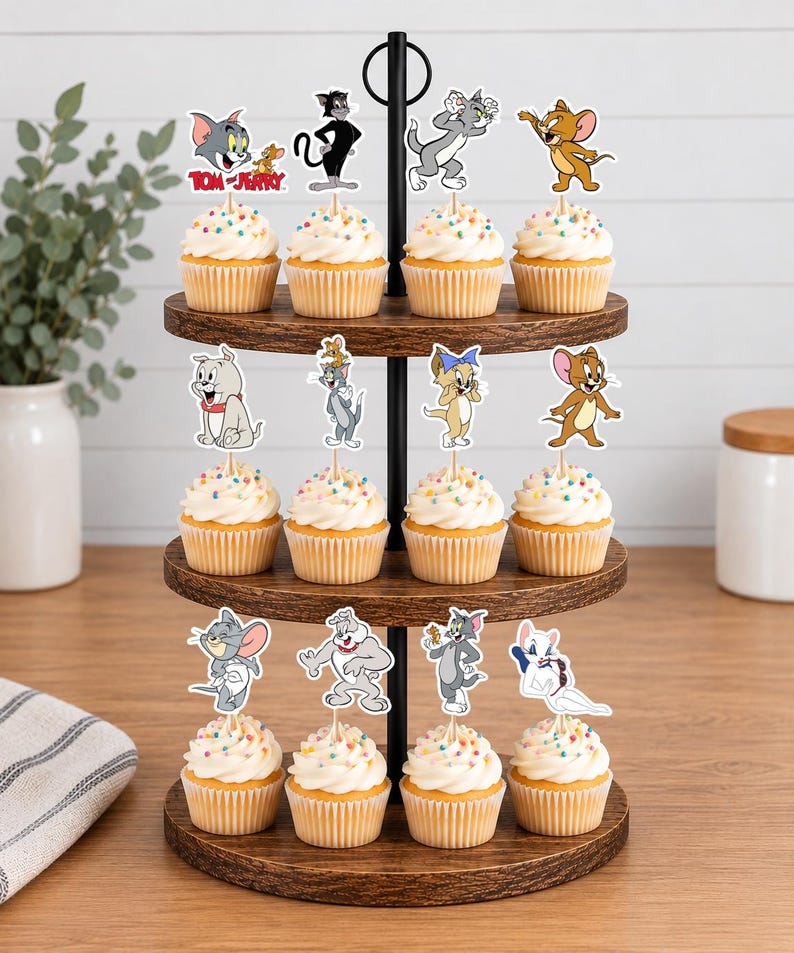 Peut inclure: Un pr&eacute;sentoir &agrave; cupcakes en bois &agrave; trois niveaux contenant douze cupcakes garnis de vermicelles color&eacute;s et de d&eacute;corations en papier Tom et Jerry. Les d&eacute;corations repr&eacute;sentent diverses poses de Tom, Jerry, Tuffy, Spike et d'autres personnages.