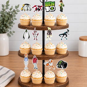 May include: A three-tiered wooden cupcake stand holding twelve cupcakes topped with white frosting and colourful sprinkles. Each cupcake features a Ben 10 themed paper topper, including various character illustrations and the Ben 10 logo text.