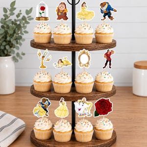 May include: A three-tiered wooden cupcake stand holding twelve cupcakes topped with white frosting and colorful sprinkles. Each cupcake features a decorative paper topper depicting characters and objects from Beauty and the Beast, including the rose, clock, and teapot.