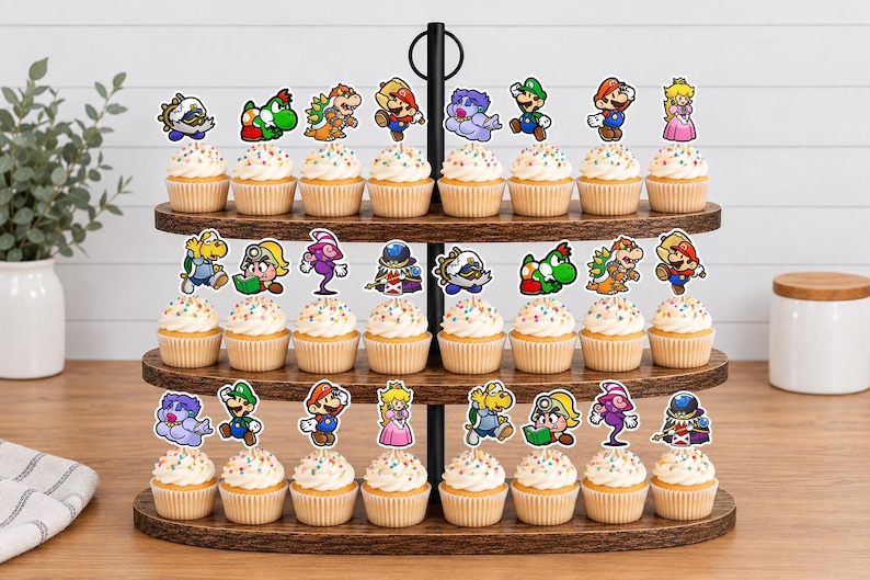 May include: A three-tiered wooden cupcake stand holding twenty-four cupcakes, each topped with a colorful paper cutout of various Super Mario characters including Mario, Luigi, Princess Peach, Yoshi, Bowser, and other iconic figures from the game series.