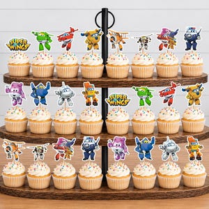 K&ouml;nnte beinhalten: Ein dreist&ouml;ckiger Cupcake-St&auml;nder aus Holz mit vierundzwanzig Cupcakes, die jeweils mit einem Super Wings-Charakter oder Logo-Aufstecker versehen sind. Die Cupcakes haben eine wei&szlig;e Glasur mit bunten Streuseln und stehen auf den dunklen Holzablagen.