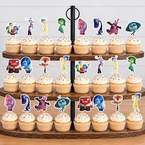 May include: A three-tiered wooden cupcake stand holding twenty-four cupcakes, each topped with a paper cutout of a character from the movie Inside Out. The cupcakes feature white frosting with colorful sprinkles and are arranged on dark wood shelves.