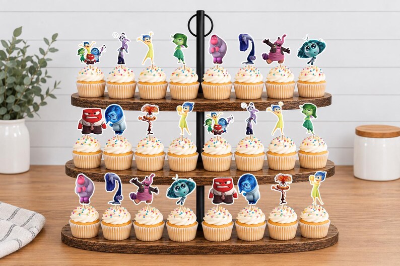 May include: A three-tiered wooden cupcake stand holding twenty-four cupcakes, each topped with a paper cutout of a character from the movie Inside Out. The cupcakes feature white frosting with colorful sprinkles and are arranged on dark wood shelves.