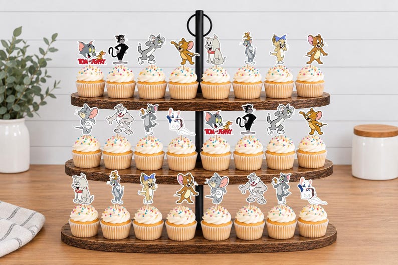 Peut inclure: Un pr&eacute;sentoir &agrave; cupcakes en bois &agrave; trois niveaux contenant vingt-quatre cupcakes, chacun surmont&eacute; d'une d&eacute;coupe en papier color&eacute;e repr&eacute;sentant les personnages de Tom et Jerry. Les personnages incluent Tom, Jerry, Spike et Tuffy dans diverses poses.