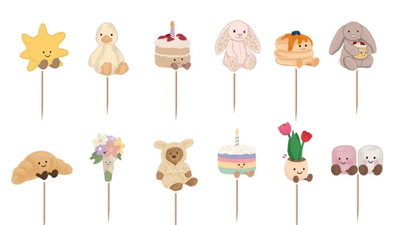 Puede incluir: Un conjunto de doce adornos decorativos para cupcakes con personajes ilustrados que incluyen un sol amarillo, un pato, un pastel, un conejo, tortitas, un oso, un cruas&aacute;n, un ramo de flores, un osito de peluche, un pastel arco&iacute;ris, tulipanes y nubes.