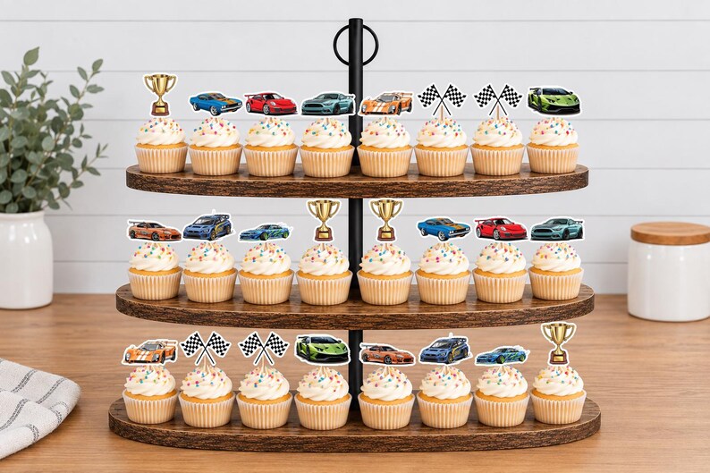 May include: A three-tiered wooden cupcake stand holding twenty-four cupcakes topped with paper cutouts featuring various colorful sports cars, gold trophies, and black and white checkered racing flags arranged in rows on each level.