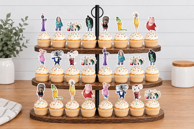 May include: A three-tiered wooden cupcake stand holding twenty-four cupcakes topped with white frosting and colorful sprinkles. Each cupcake features a paper topper depicting various animated characters from the movie Sing, including the Sing logo.