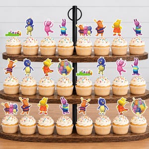 May include: A three-tiered wooden stand holding twenty-four cupcakes topped with colorful paper cutouts of cartoon characters from The Backyardigans. Each cupcake features a different character pose or group illustration on a small stick.