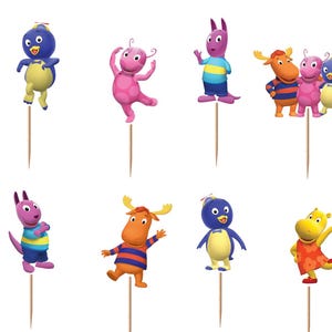 May include: A collection of The Backyardigans character toppers on wooden sticks. The toppers feature cartoon characters in various poses and colors, including blue, pink, orange, and yellow. The Backyardigans logo is also included.