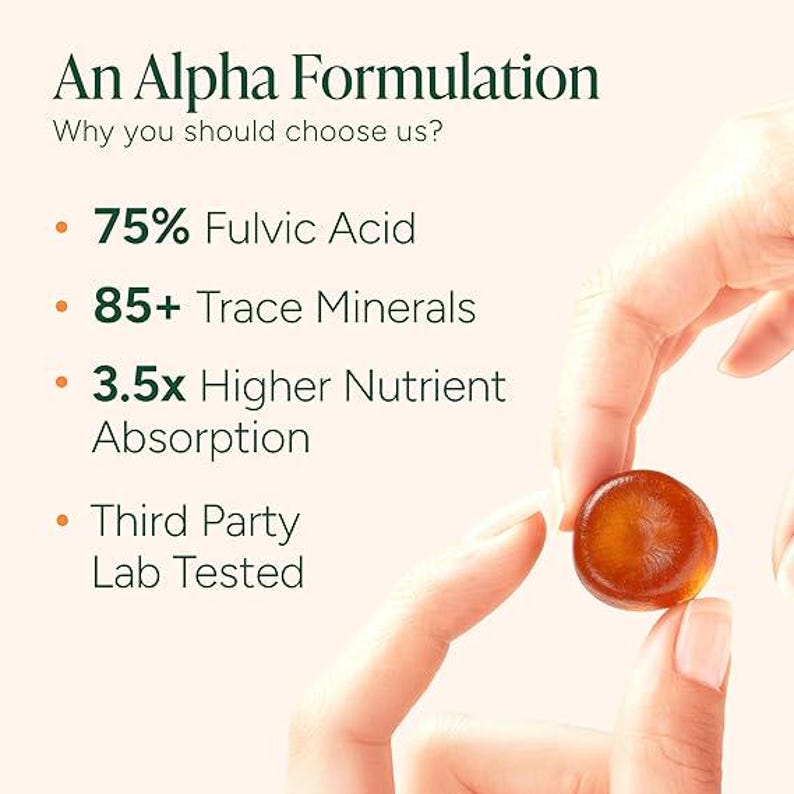 Pu&ograve; includere: Immagine di un prodotto 'An Alpha Formulation'. Una mano tiene in mano un piccolo integratore rotondo color ambra. Il testo a sinistra elenca i vantaggi: 75% di acido fulvico, 85+ minerali traccia, 3,5x maggiore assorbimento dei nutrienti e testato in laboratorio da terzi.
