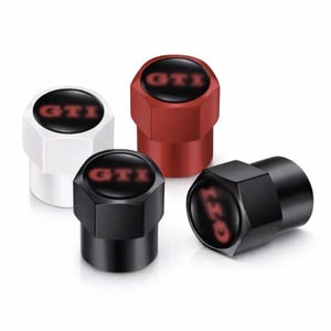 Peut inclure: Un ensemble de quatre bouchons de valve de pneu hexagonaux aux finitions blanche, rouge et noire. Chaque bouchon présente un insert circulaire noir sur le dessus avec le texte GTI imprimé en rouge au centre. Surface extérieure lisse.