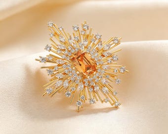 Broche Art Déco em formato de estrela com cristal âmbar e alfinete em formato de sol com zircônia dourada.