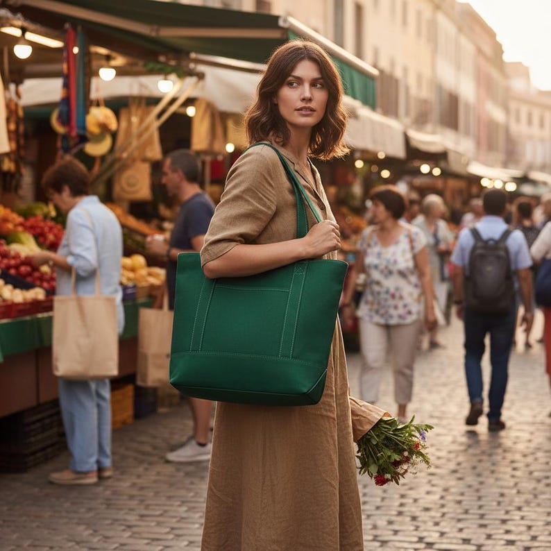 May include: A woman carries a large, emerald green tote bag with a rectangular shape and reinforced handles. The bag is made of a sturdy material and is suitable for shopping or carrying everyday items. The woman is in a market setting.