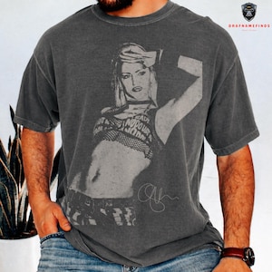 Peut inclure: T-shirt gris fonc&eacute; avec un graphisme noir et blanc d'une femme et le texte "READY NO DOUBT NOW". Le t-shirt a un aspect vintage et us&eacute; et un col rond.