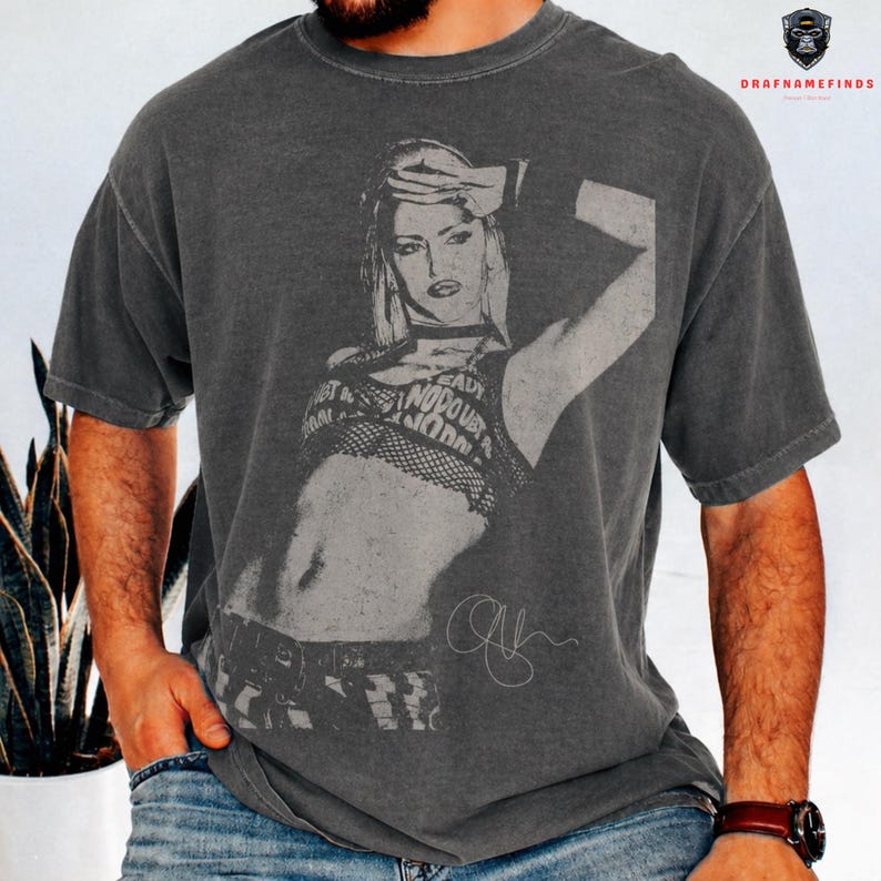 Peut inclure: T-shirt gris fonc&eacute; avec un graphisme noir et blanc d'une femme et le texte "READY NO DOUBT NOW". Le t-shirt a un aspect vintage et us&eacute; et un col rond.