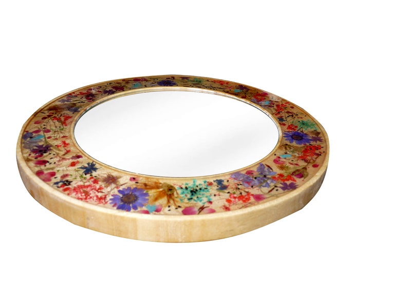 May include: A round mirror with a wooden frame decorated with pressed flowers in shades of pink, purple, blue, green, and yellow.