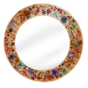 May include: Round mirror with a decorative frame made of pressed flowers. The frame features a variety of dried flowers in shades of pink, purple, blue, yellow, and red.