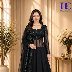 Può includere: Un abito da sera nero con maniche lunghe e un corpetto trasparente. L'abito presenta intricati dettagli in pizzo sul corpetto e sulle maniche, con una gonna fluida. L'abito è impreziosito da abbellimenti color verde acqua. Il logo "DC Dheyly Creation" è in alto a destra.