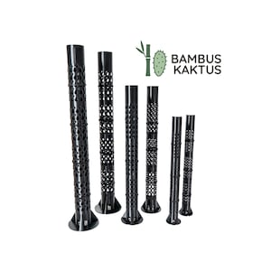 Könnte beinhalten: Sechs schwarze, zylindrische Pflanzenstützen in verschiedenen Höhen, jede mit einem sich wiederholenden Muster aus tropfenförmigen Ausschnitten und einem runden Fuß. Das Logo BAMBUS KAKTUS ist in der oberen rechten Ecke zu sehen.
