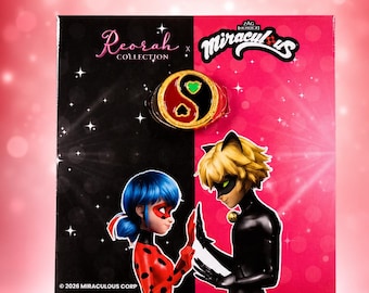 May include: A Miraculous collection display card featuring a gold-toned yin-yang ring with red and black enamel and a small green heart. The card shows Ladybug and Cat Noir characters with the text Reorah Collection and Miraculous Zag Heroez.
