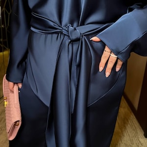 Detail of satin two piece pants set showing adjustable waist belt and smooth silk look fabric