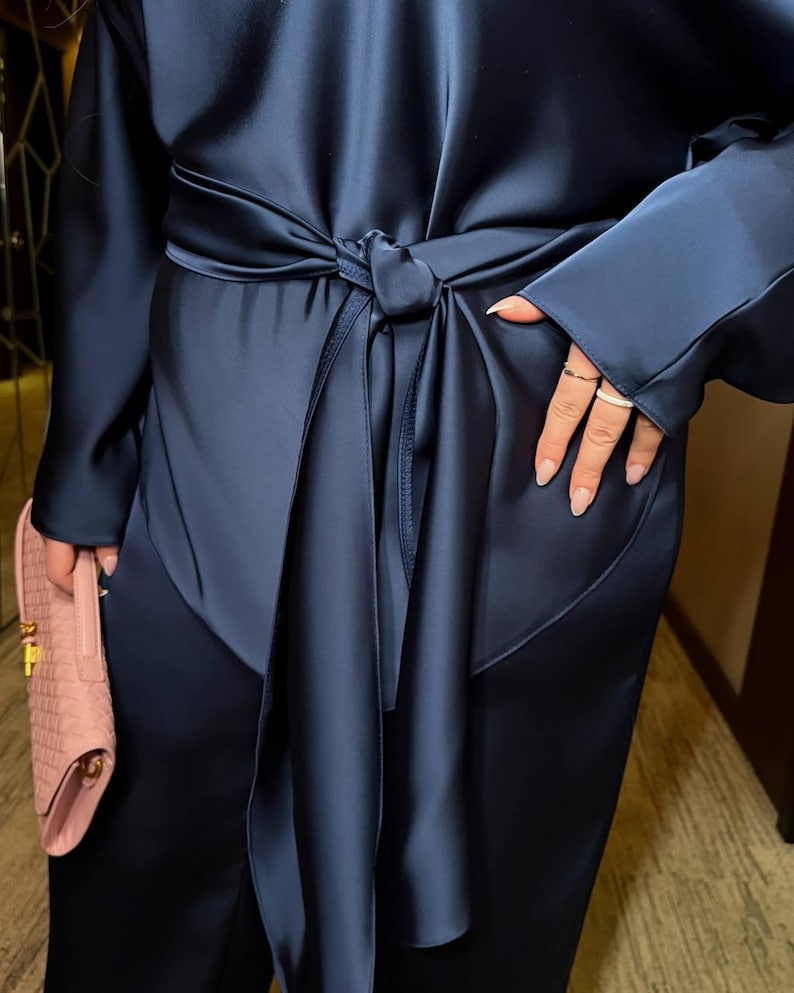 Detail of satin two piece pants set showing adjustable waist belt and smooth silk look fabric