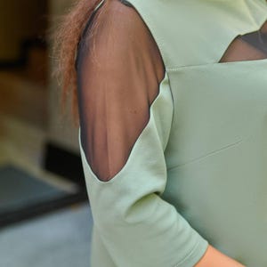 Close up of mesh sleeve detail on plus size midi dress, sheer fabric and elegant design