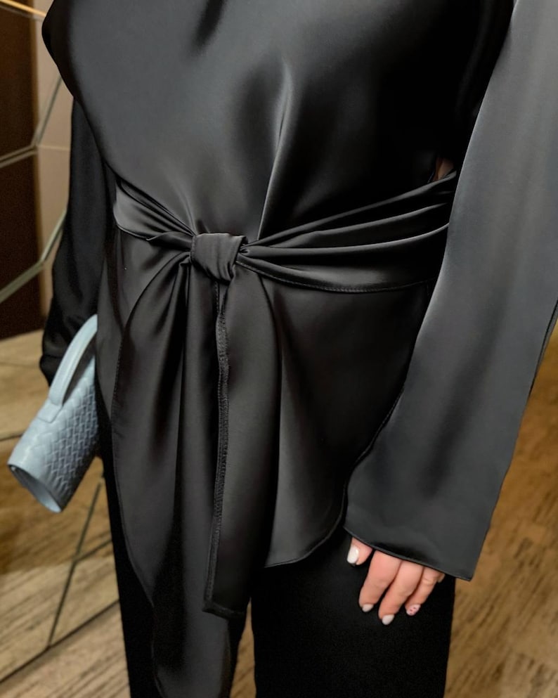 Detail of satin women pantsuit showing adjustable tie belt and smooth silk look fabric