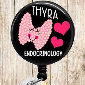 May include: Black and pink badge reel with a cartoon thyroid gland with a smiling face and two pink hearts. The text "Thyra Endocrinology" is printed on the reel.