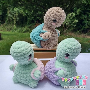 May include: Three crocheted turtle plushies in different colors. The turtles are sitting on a wooden surface. The turtles are handmade in Florida.