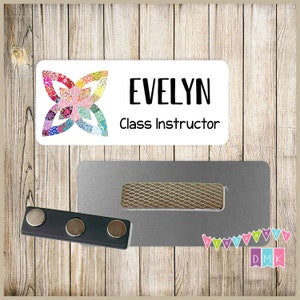 May include: A white name tag with the name "EVELYN" and the title "Class Instructor" in black text. The tag features a colorful floral design and a magnetic backing for attachment.