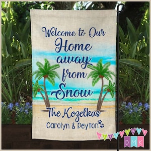 May include: A welcome sign with a beach scene and palm trees. The text reads "Welcome to Our Home away from Snow The Kozelkas Carolyn & Peyton".