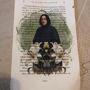 May include: A page from a book with a printed image of a character from the Harry Potter series, Severus Snape, superimposed over a floral design. The text on the page is from Chapter Thirteen.