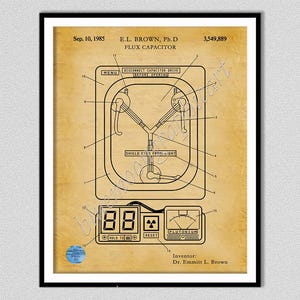 May include: A framed patent print on aged tan paper featuring a technical diagram of a flux capacitor. The illustration includes black line drawings, numbered labels, and text reading Sep. 10, 1985, E.L. Brown, Ph.D, 3,549,889, and Inventor: Dr. Emmitt L. Brown.