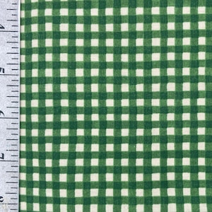 May include: Close-up of green and white checkered fabric. The fabric has a classic gingham pattern, with evenly spaced squares of green and white. The fabric is likely cotton or a similar material, suitable for quilting or apparel.