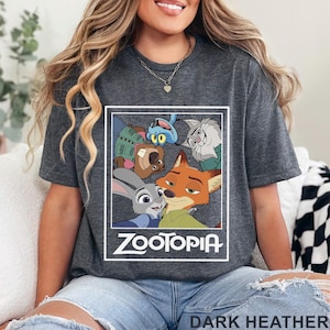 May include: Dark heather grey t-shirt with a Zootopia graphic. The design features characters from the animated film, including Judy Hopps and Nick Wilde, with the word "Zootopia" in white. The shirt is made of a soft material.