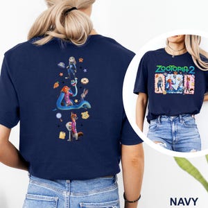 May include: Navy blue t-shirt featuring a colorful graphic from the movie "Zootopia 2" on the front and back. The back design includes characters like Judy Hopps, Nick Wilde, and others. The front design has the movie title and characters.
