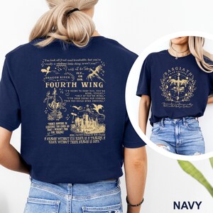 May include: Navy blue t-shirts with graphic designs. One shirt features text and illustrations related to "Fourth Wing" and "Dragon Rider." The other shirt displays a circular design with text, a dragon, and the words "Basgiath War College."