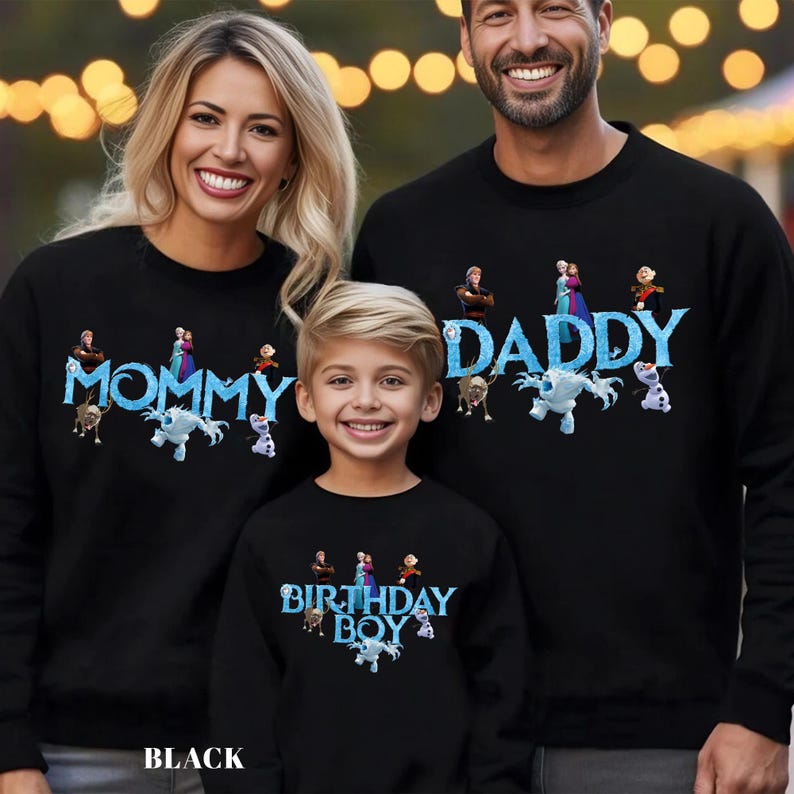 May include: Black sweatshirts with the words "MOMMY", "DADDY", and "BIRTHDAY BOY" in blue, along with cartoon characters. The sweatshirts are worn by a family of three. The word "BLACK" is at the bottom of the image.