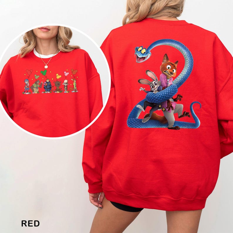 May include: A bright red crewneck sweatshirt featuring a large graphic on the back of a blue snake coiled around a fox and a rabbit character. The front chest area displays a smaller graphic of several cartoon characters holding colorful balloons.