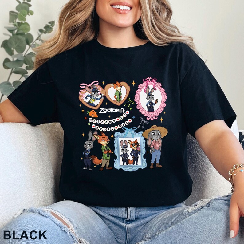 Puede incluir: Una camiseta negra con un estampado gr&aacute;fico de los personajes de Zootopia, incluyendo a Judy Hopps y Nick Wilde. El dise&ntilde;o incluye varias ilustraciones enmarcadas, peque&ntilde;as estrellas, lazos y el texto "ZOOTOPIA WELCOME TO ZOOTOPIA" en blanco.