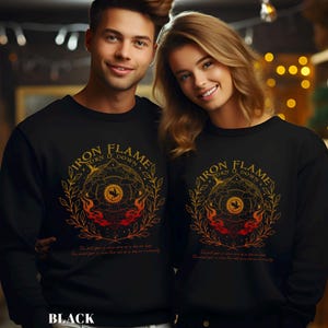 May include: Black sweatshirts with a circular graphic featuring the text "IRON FLAME TURN IT DOWN" in gold lettering. The design includes a central emblem, flames, and botanical elements. The text "The full year is when one of us live our lives. The mind year is when the rest of us live eternally" is below the graphic.