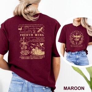 May include: Maroon t-shirt featuring the text "FOURTH WING" with a dragon and castle graphic. The back of the shirt has additional text and illustrations. The shirt is made of a soft material.