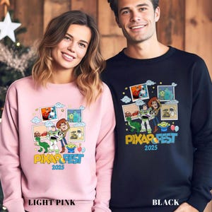 Może przedstawiać: Jasnor&oacute;żowe i czarne bluzy z kolorową grafiką z film&oacute;w Pixar. Projekt zawiera postacie takie jak Woody i Buzz Lightyear, z napisem "PIXAR FEST 2025". Jasnor&oacute;żowa bluza jest oznaczona jako "LIGHT PINK", a czarna jako "BLACK".