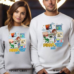 Może przedstawiać: Szare i białe bluzy z kolorową grafiką postaci z film&oacute;w Pixar. Projekt zawiera wizerunki Woody'ego, Buzza Astrala i innych postaci, z napisem "PIXAR FEST 2025" w kolorze ż&oacute;łtym i niebieskim.
