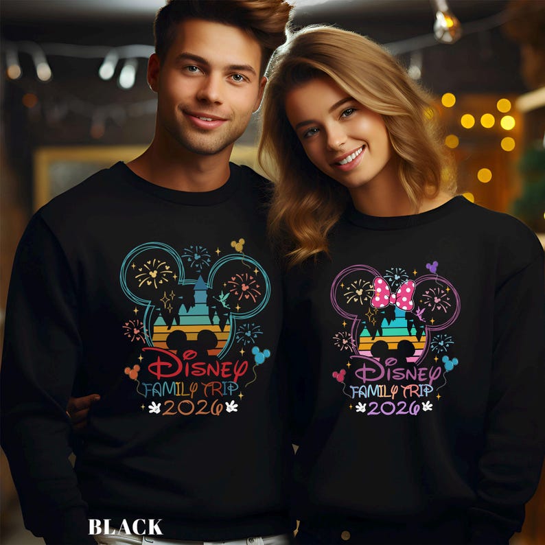 May include: Black sweatshirts with a colorful Disney design. One features a Mickey Mouse head with fireworks, the text "Disney Family Trip 2026", and Mickey Mouse icons. The other has a Minnie Mouse head with a bow and the same text.