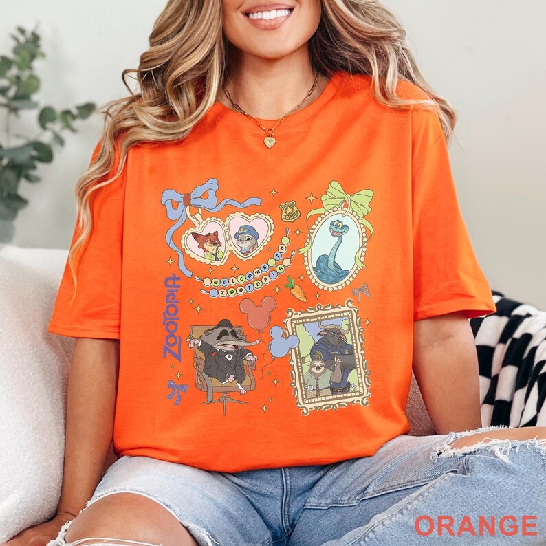 Puede incluir: Camiseta naranja con ilustraciones coloridas de la pel&iacute;cula "Zootr&oacute;polis". El dise&ntilde;o incluye retratos de personajes enmarcados, una placa de polic&iacute;a y el t&iacute;tulo de la pel&iacute;cula en azul. Una prenda c&oacute;moda e informal.